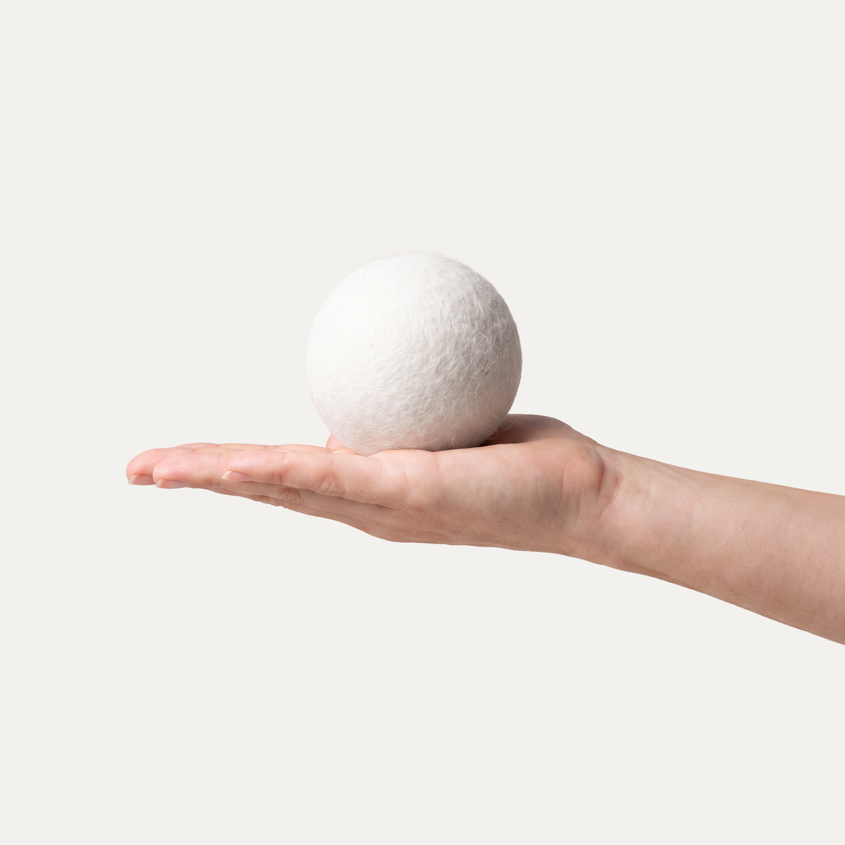 Ein bluu ball liegt auf einer ausgestreckten Hand vor hellem Hintergrund.
