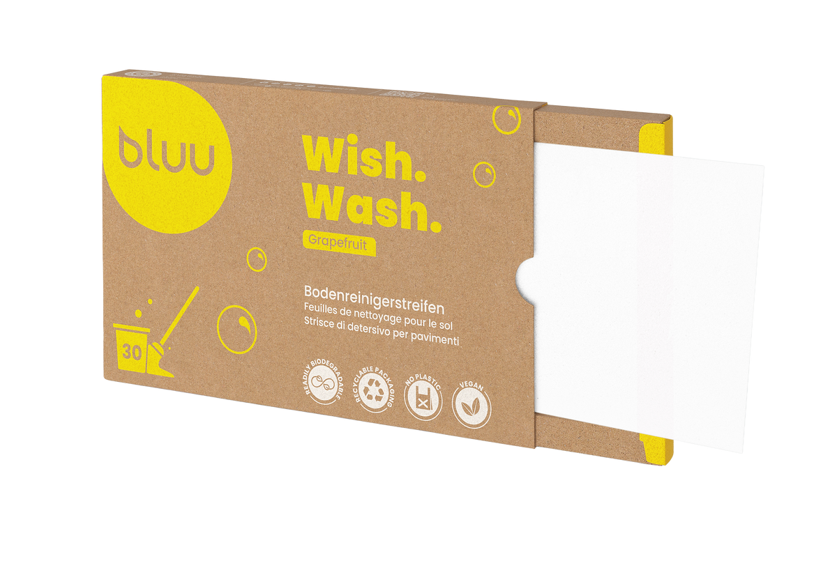 Geöffnete bluu «Wish. Wash.» Verpackung Bodenreinigerstreifen Grapefruit mit herausgezogenem Reinigerstreifen.
