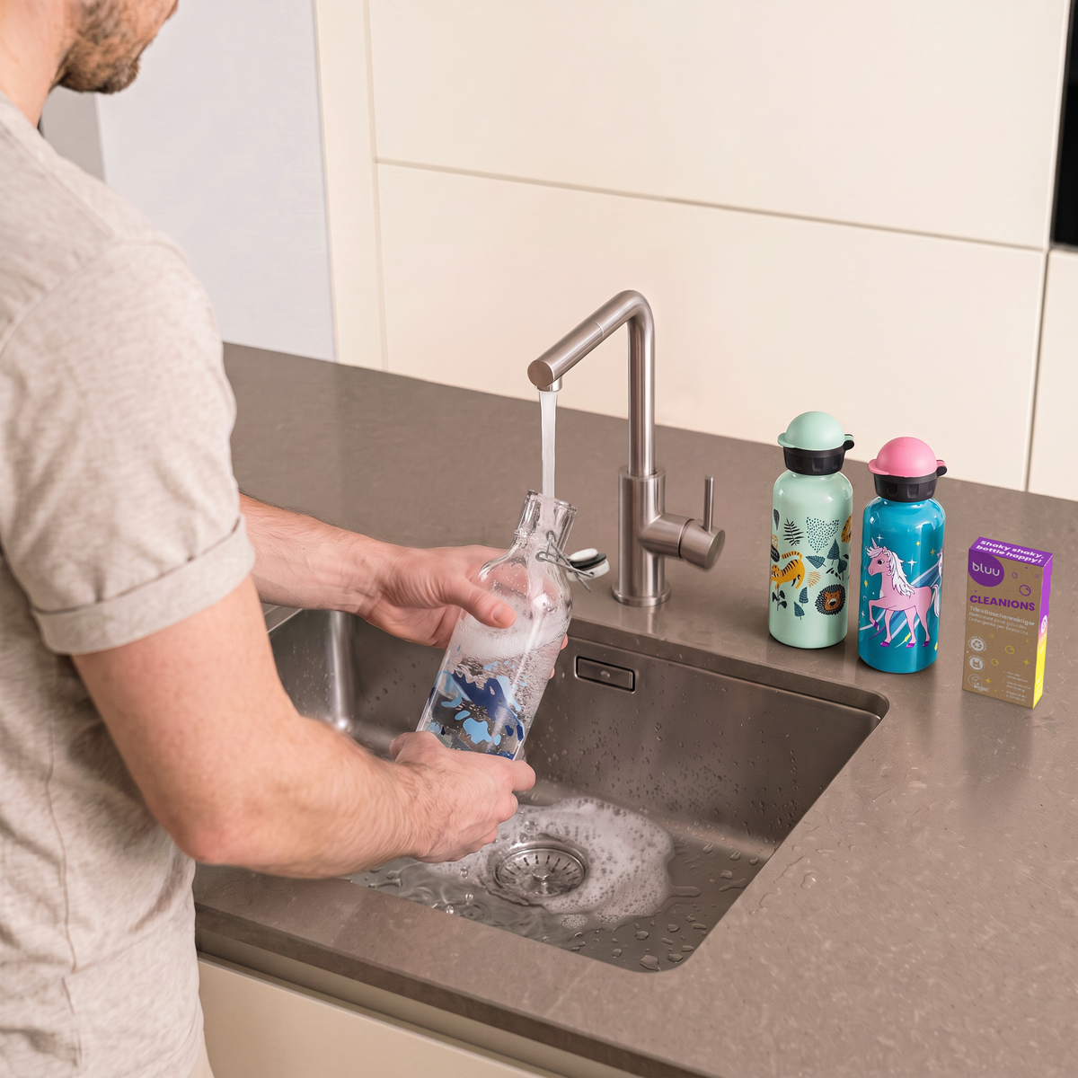 bluu Trinkflasche wird mit Cleanions Trinkflaschenreiniger gereinigt. 