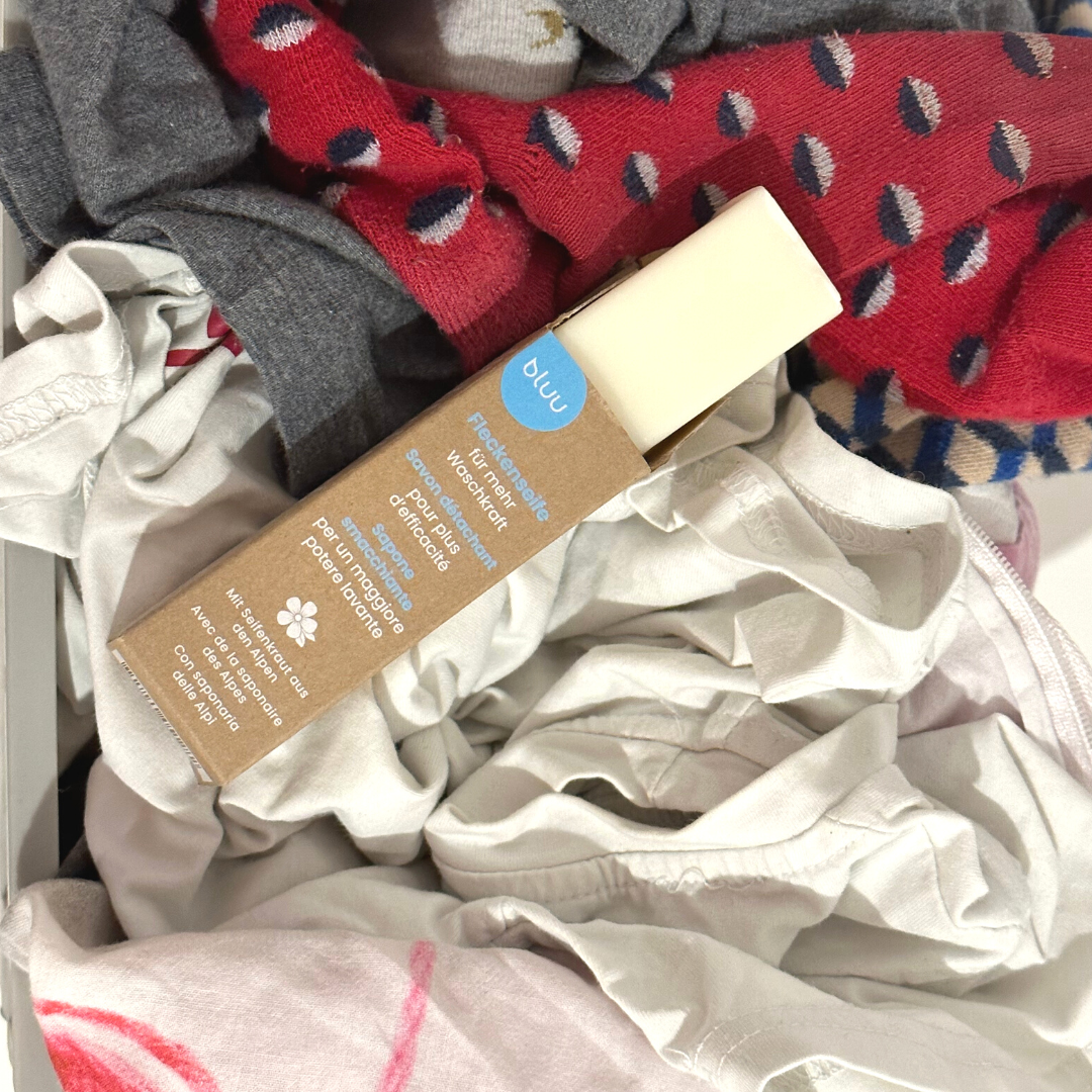 bluu Fleckenseife – Verpackung auf bunter Wäsche